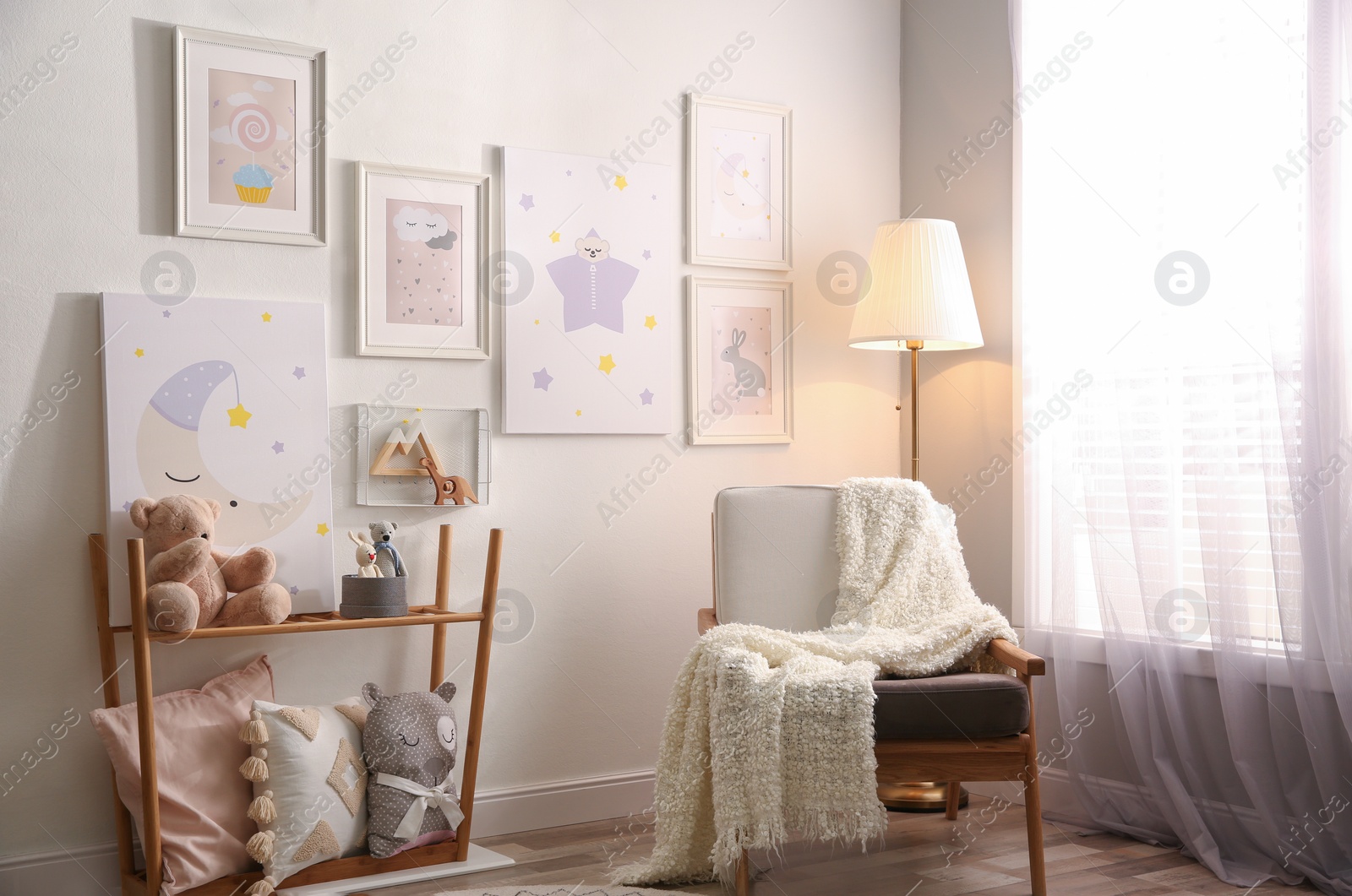 Photo of Stylish child's room interior with comfortable armchair and beautiful pictures