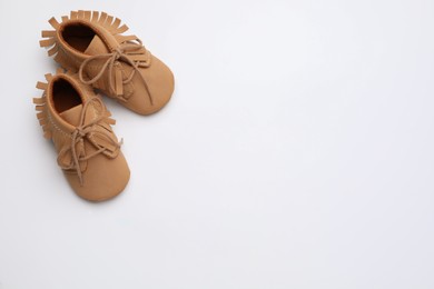 Photo of Cute baby shoes on white background, top view. Space for text