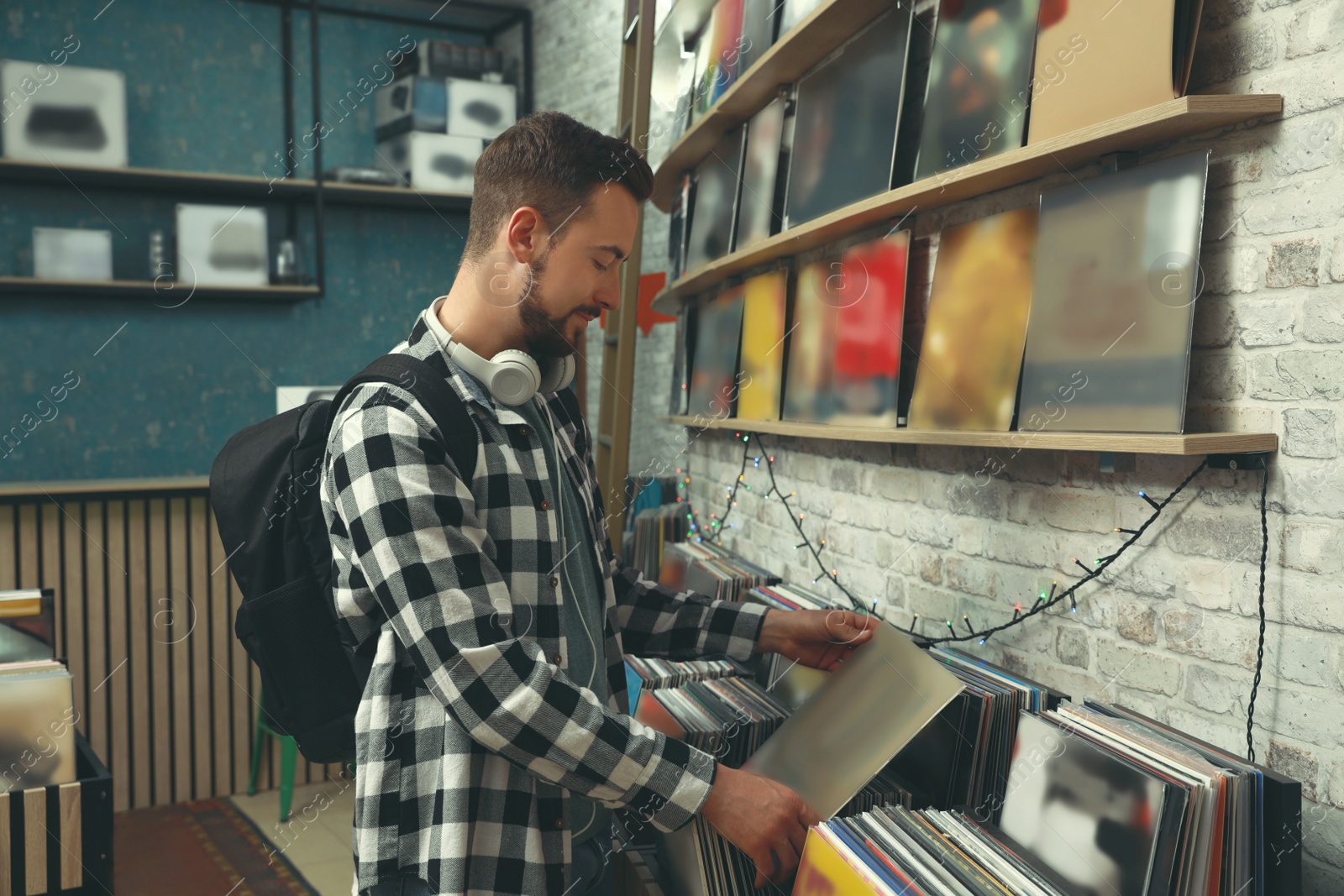 Image of Young man choosing vinyl records in store