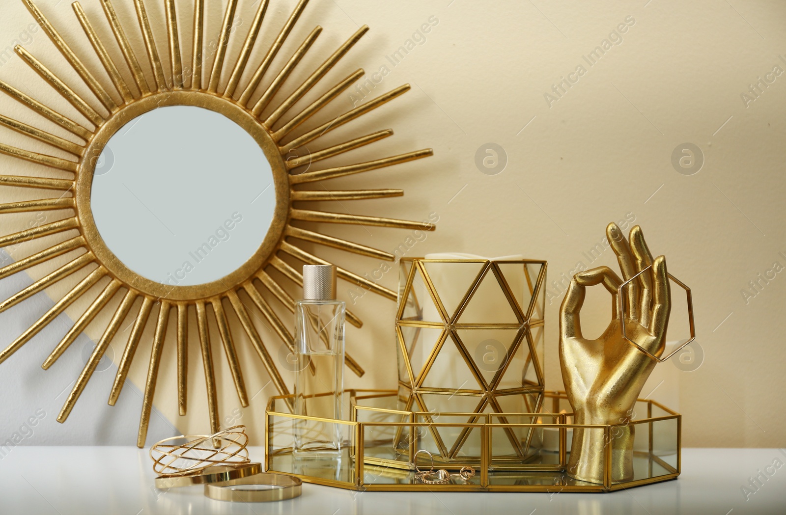 Photo of Composition with golden accessories and jewelry on dressing table near color wall