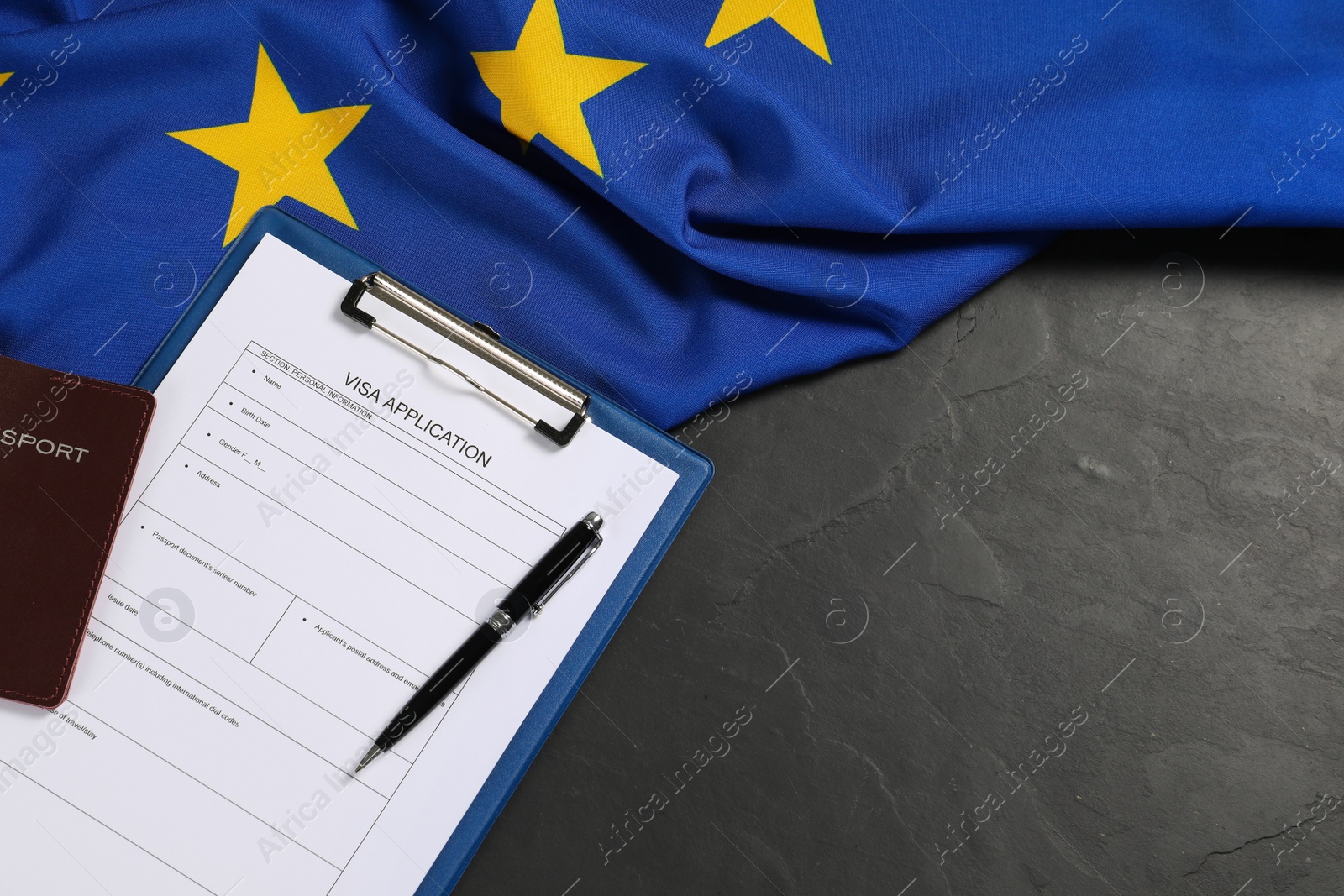 Photo of Visa application form, passport, pen and flag of European Union on black table, flat lay. Space for text