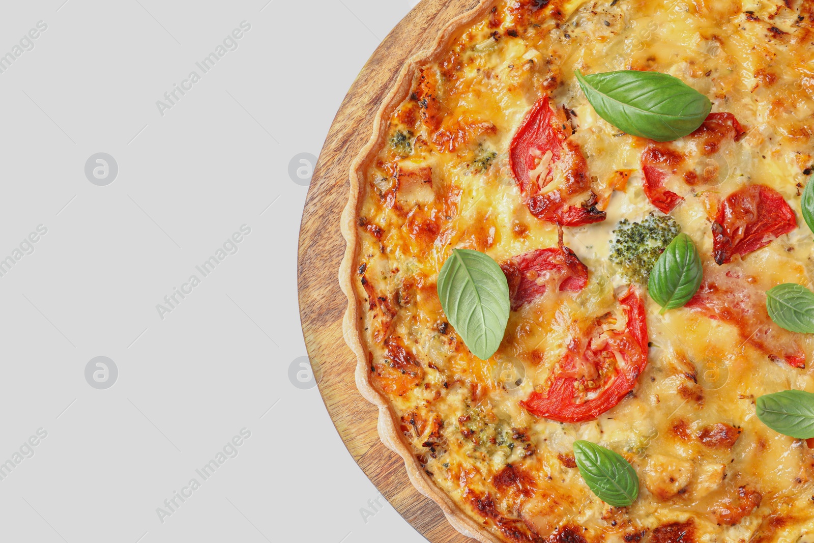 Photo of Tasty quiche with cheese, tomatoes and basil leaves on white background, top view. Space for text
