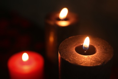 Photo of Burning black and red candles, closeup view