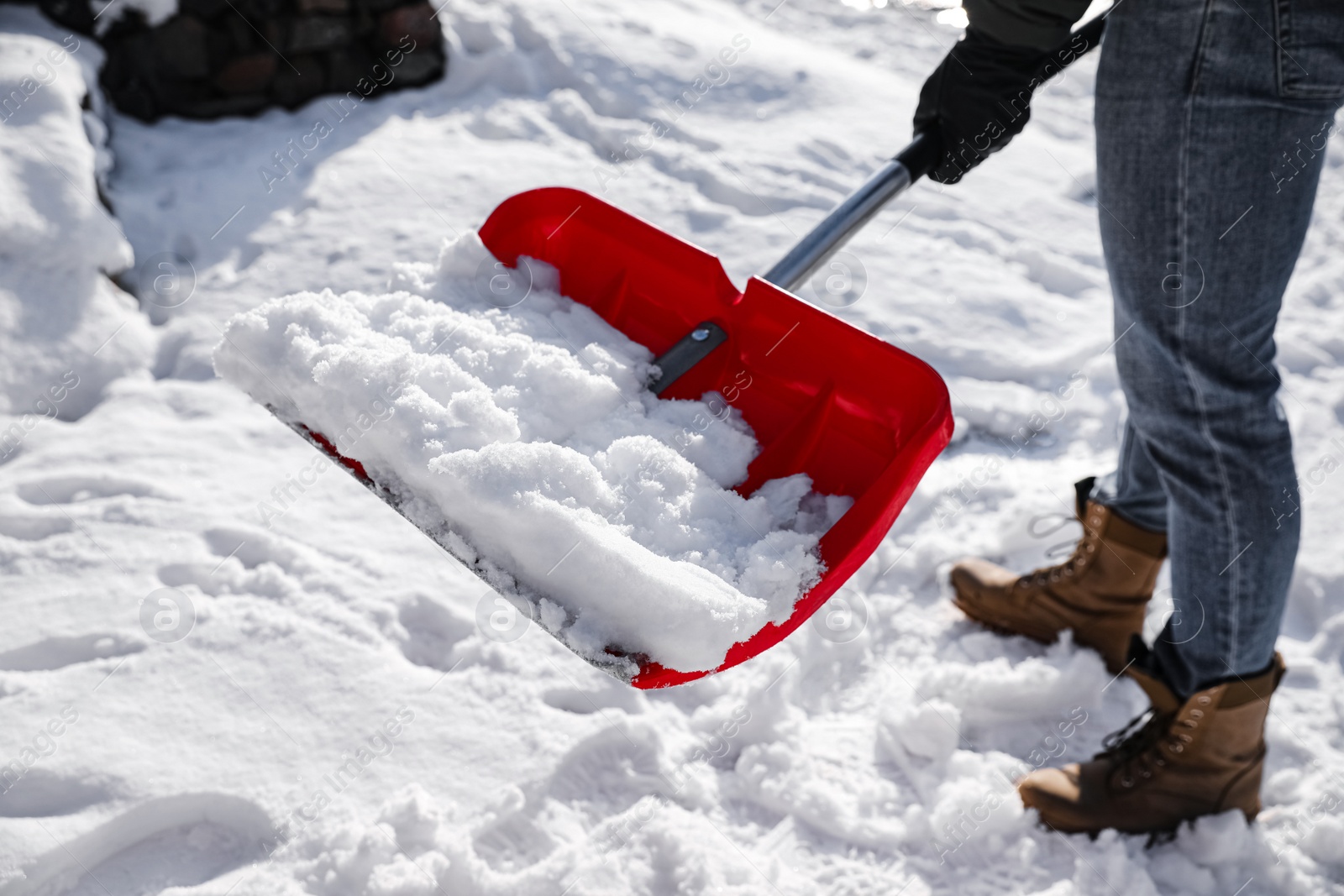 Photo of Person shoveling snow outdoors on winter day, closeup