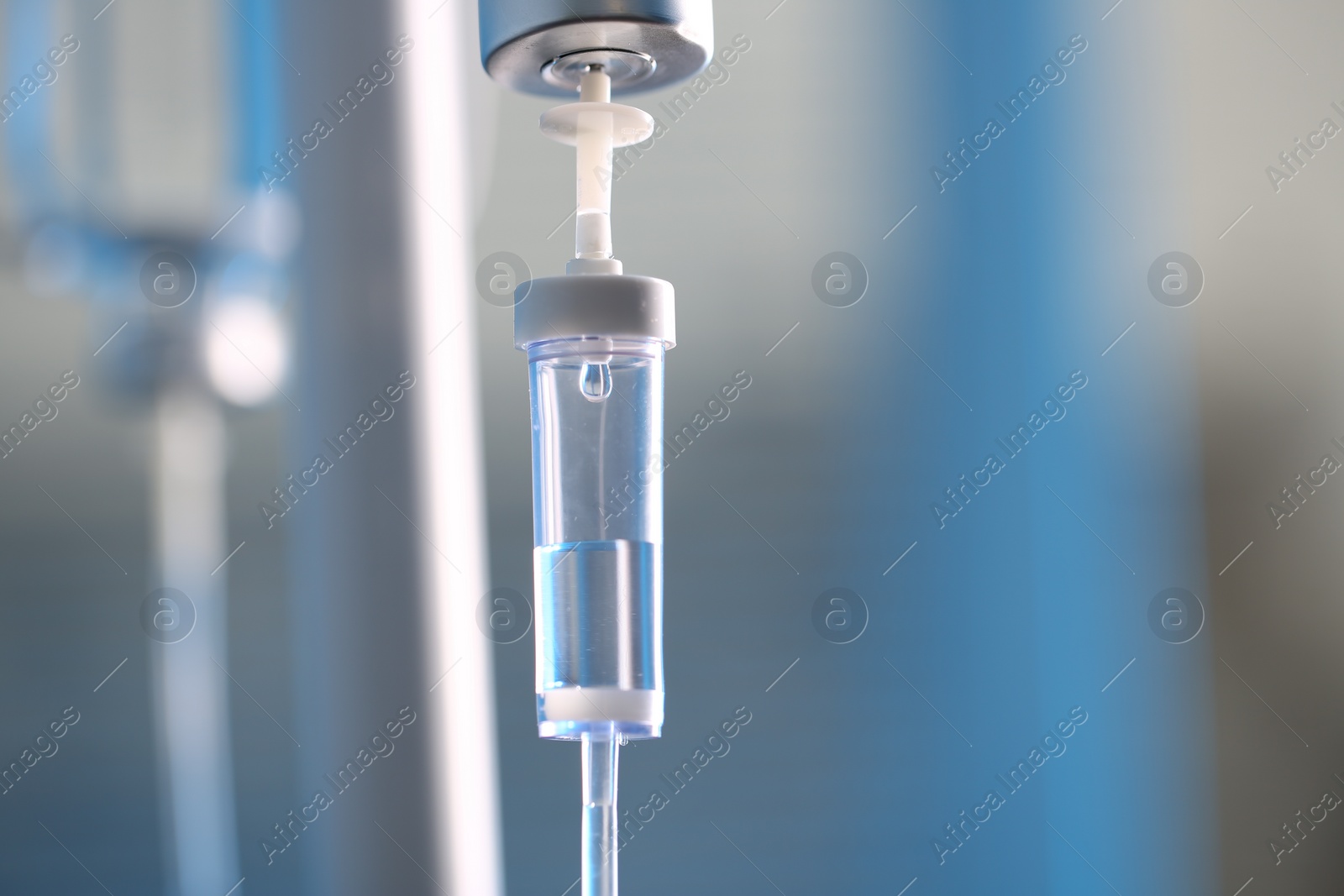 Photo of IV drip chamber against blurred light background