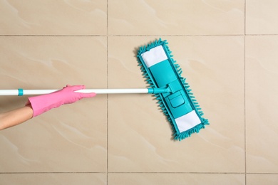 Woman cleaning floor with mop, top view