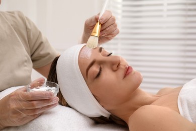 Photo of Young woman during face peeling procedure in salon