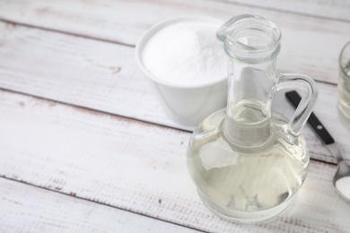 Vinegar and baking soda on white wooden table, space for text