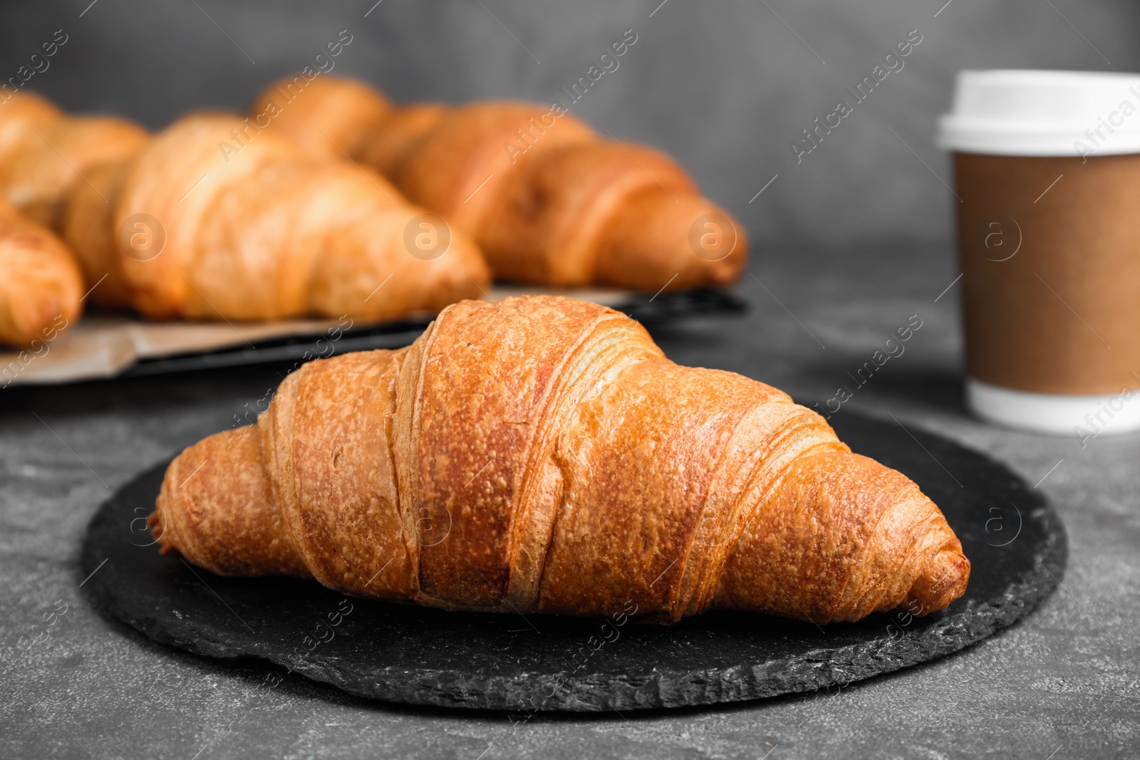 Photo of Tasty fresh crispy croissants on grey table