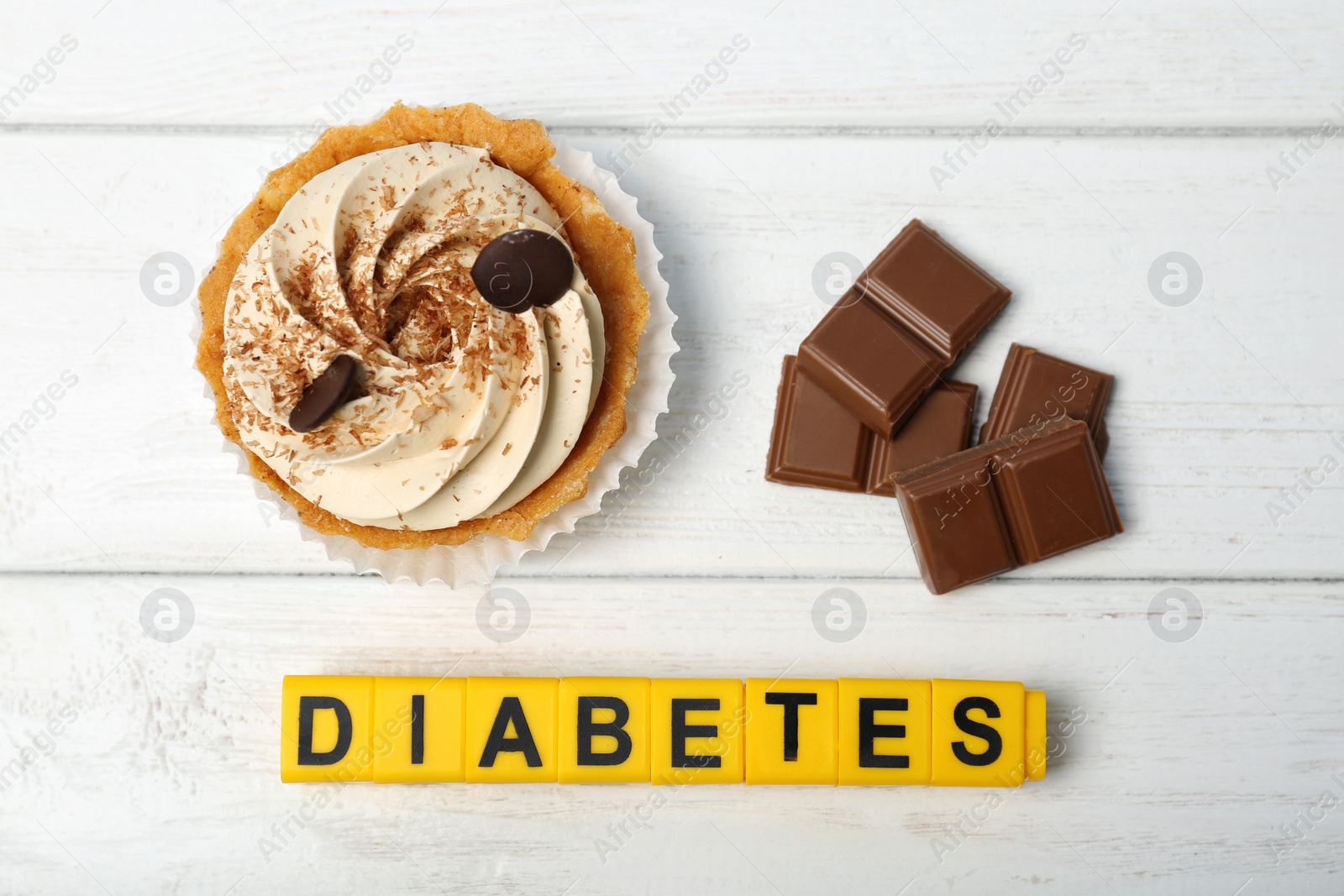 Photo of Flat lay composition with word "Diabetes" and sweets on wooden background