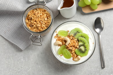 Photo of Tasty breakfast with yogurt, fruits and granola on table, top view