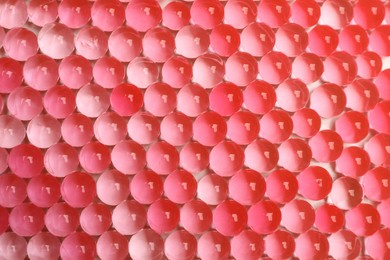 Top view of red vase filler as background. Water beads