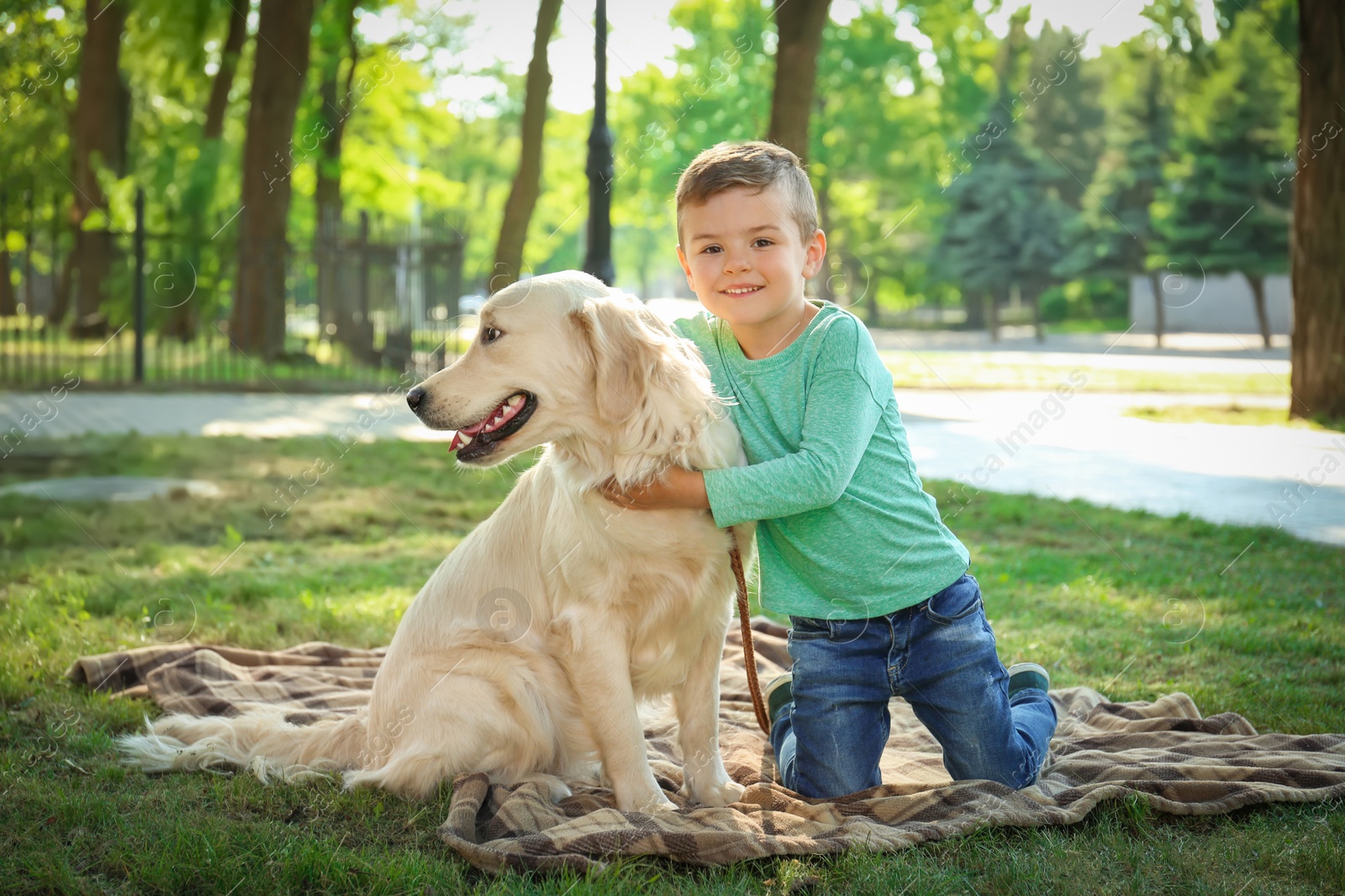 Photo of Cute little child with his pet in green park