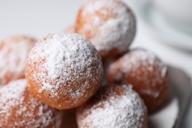 Delicious sweet buns with powdered sugar on white table, closeup