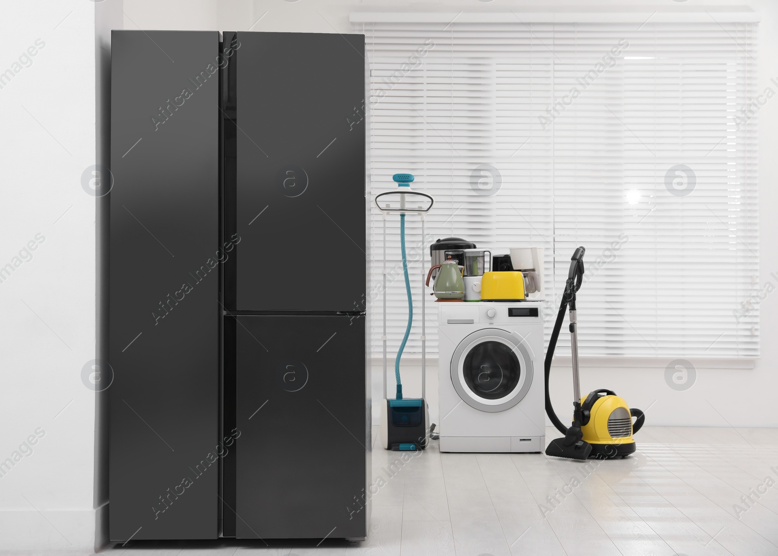 Photo of Refrigerator and different household appliances in room