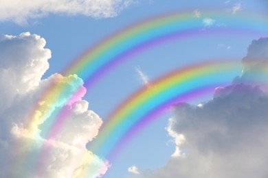 Image of Beautiful view of bright rainbows in blue sky on sunny day