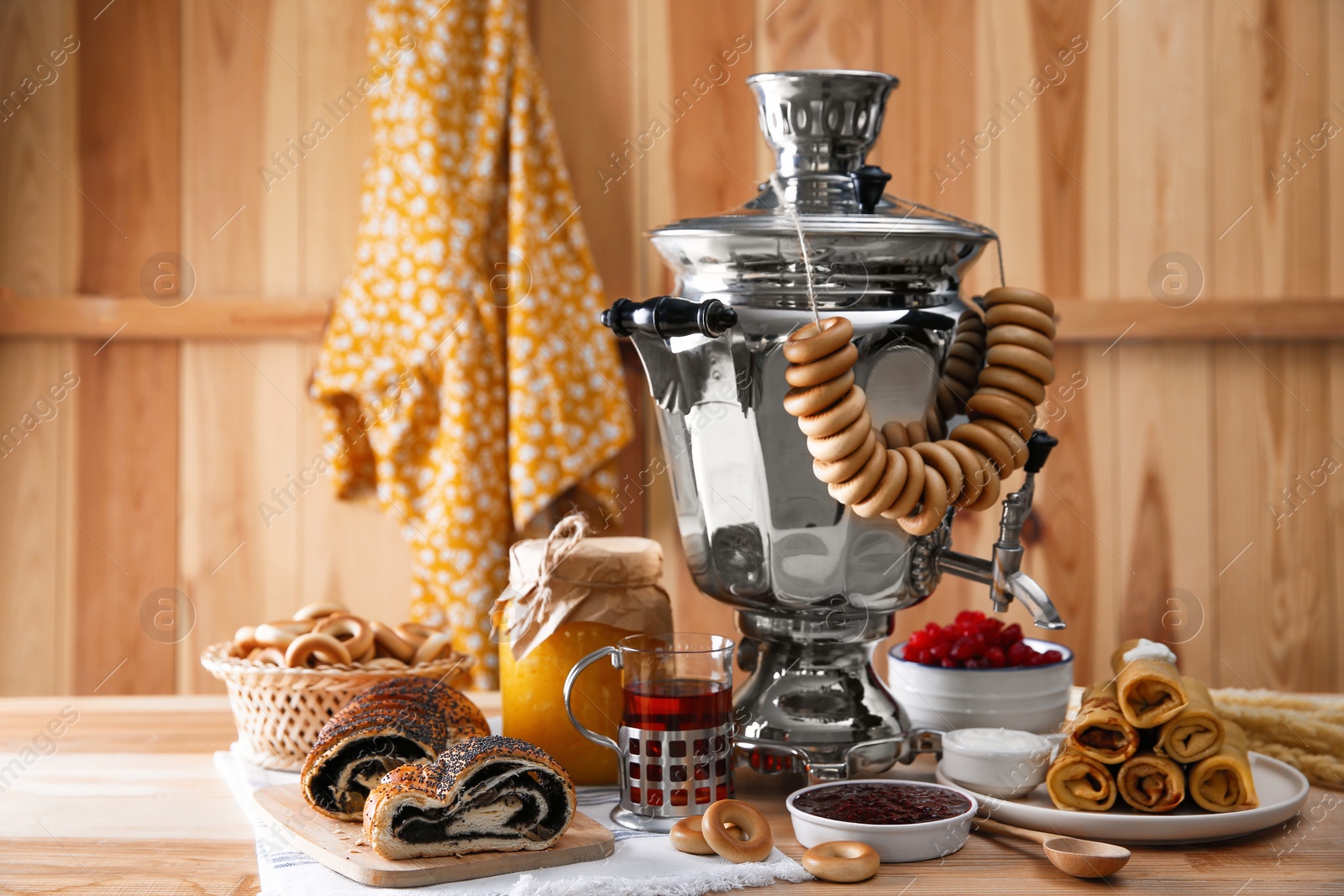 Photo of Traditional Russian samovar and treats on wooden table