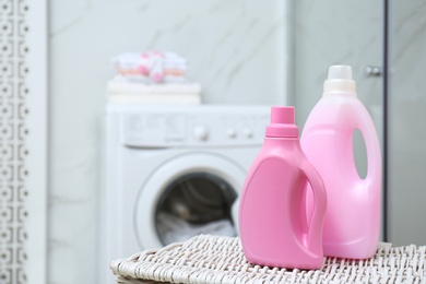 Photo of Bottles of detergent on wicker basket in bathroom. Space for text