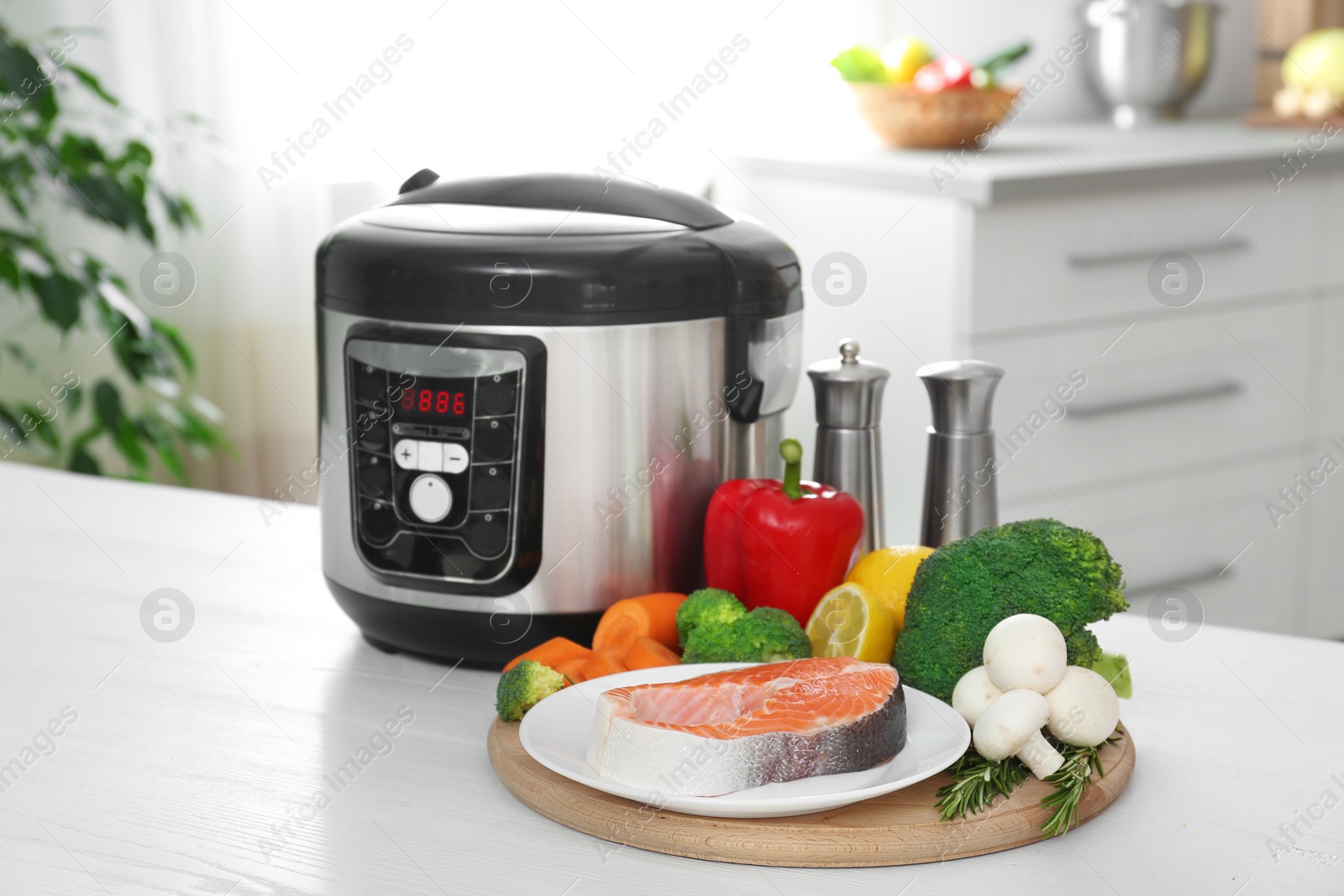 Photo of Modern multi cooker and products on kitchen table