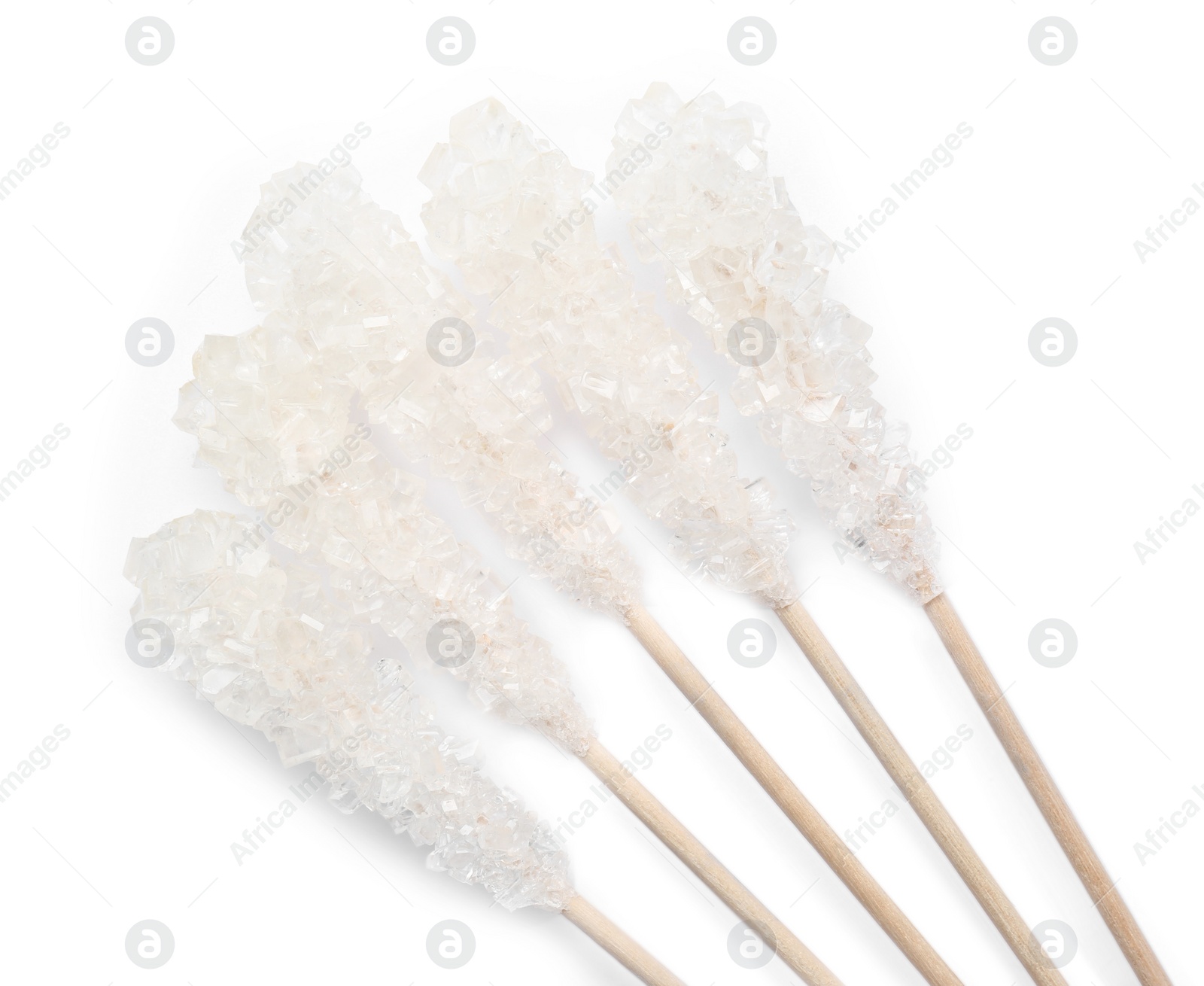 Photo of Wooden sticks with sugar crystals isolated on white, top view. Tasty rock candies