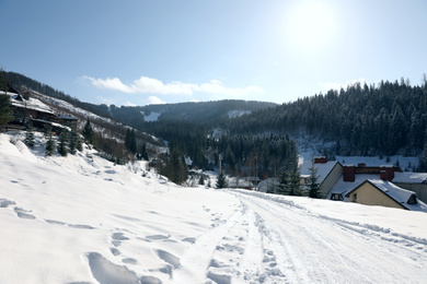 Photo of Beautiful mountain landscape with snowy hills and houses on sunny day in winter