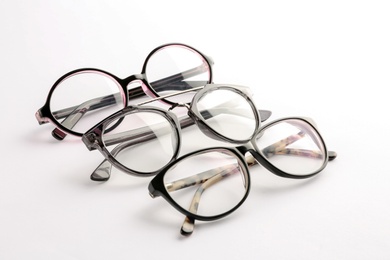 Photo of Different glasses with corrective lenses on white background. Vision problem