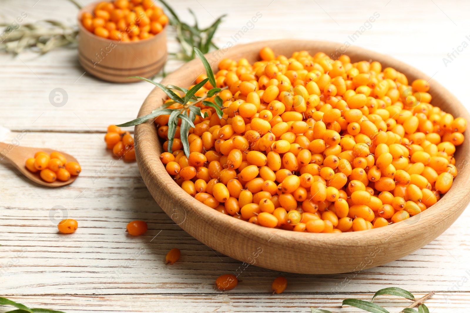 Photo of Fresh ripe sea buckthorn on white wooden table