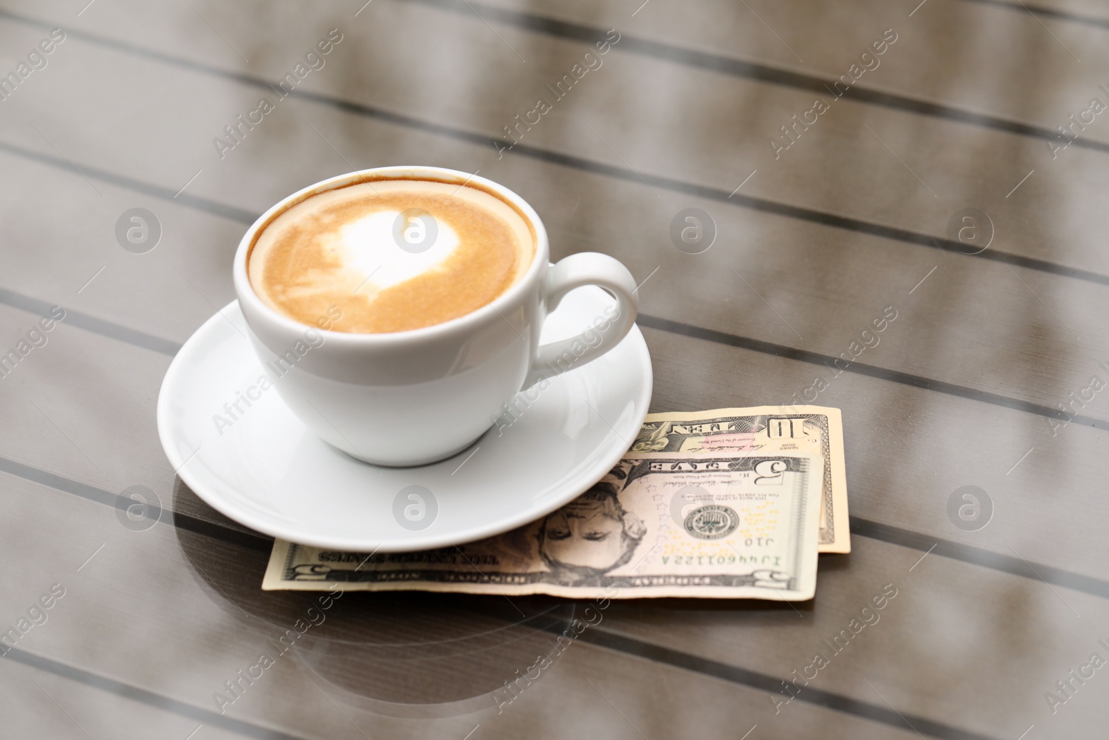 Photo of Tips and coffee on table in outdoor cafe
