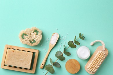 Jar of cream, body care products and eucalyptus branch on turquoise background, flat lay. Space for text