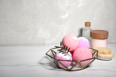 Photo of Beautiful composition with aromatic bath bombs on white marble table, space for text