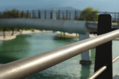 Photo of Metal handrails of bridge over canal outdoors, closeup