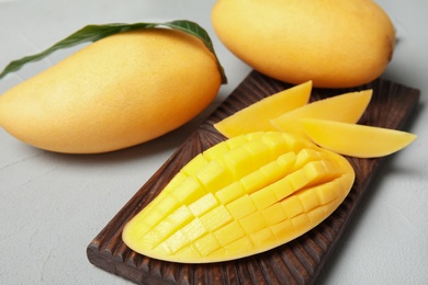 Photo of Ripe juicy mango on grey table. Tropical fruit