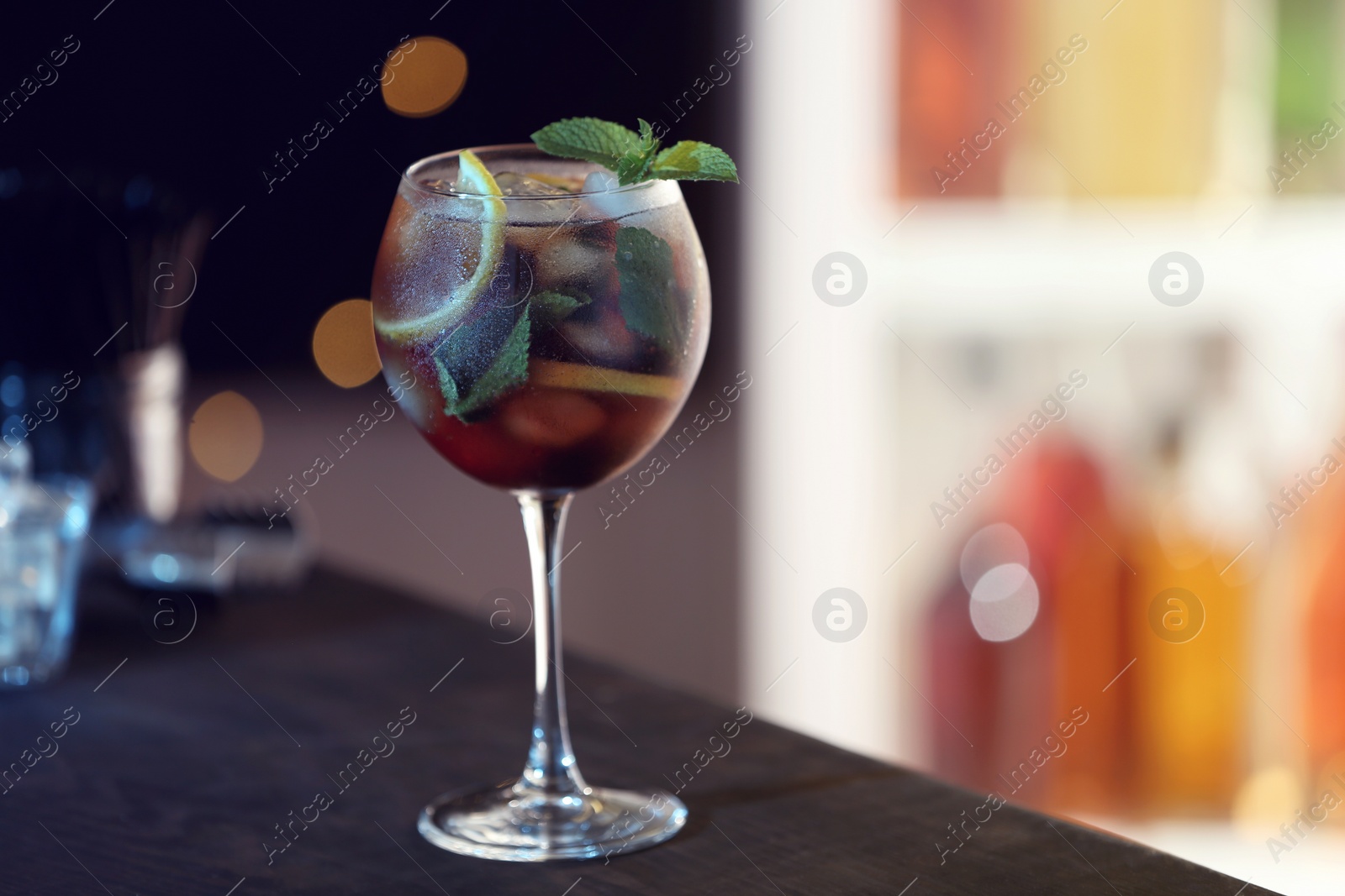 Photo of Fresh alcoholic cocktail with lemon and mint on bar counter