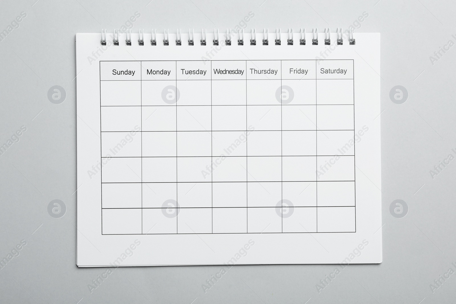Photo of Blank calendar on light grey background, top view