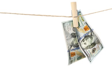 Image of Money laundering. Dollar banknotes hanging on clothesline against white background