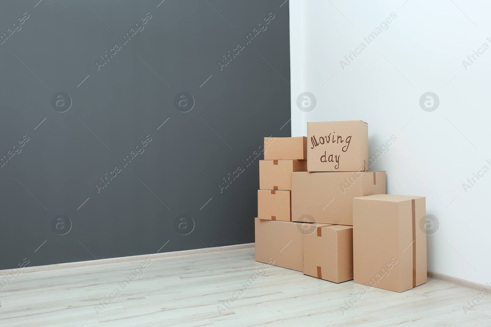 Photo of Pile of moving boxes in empty room