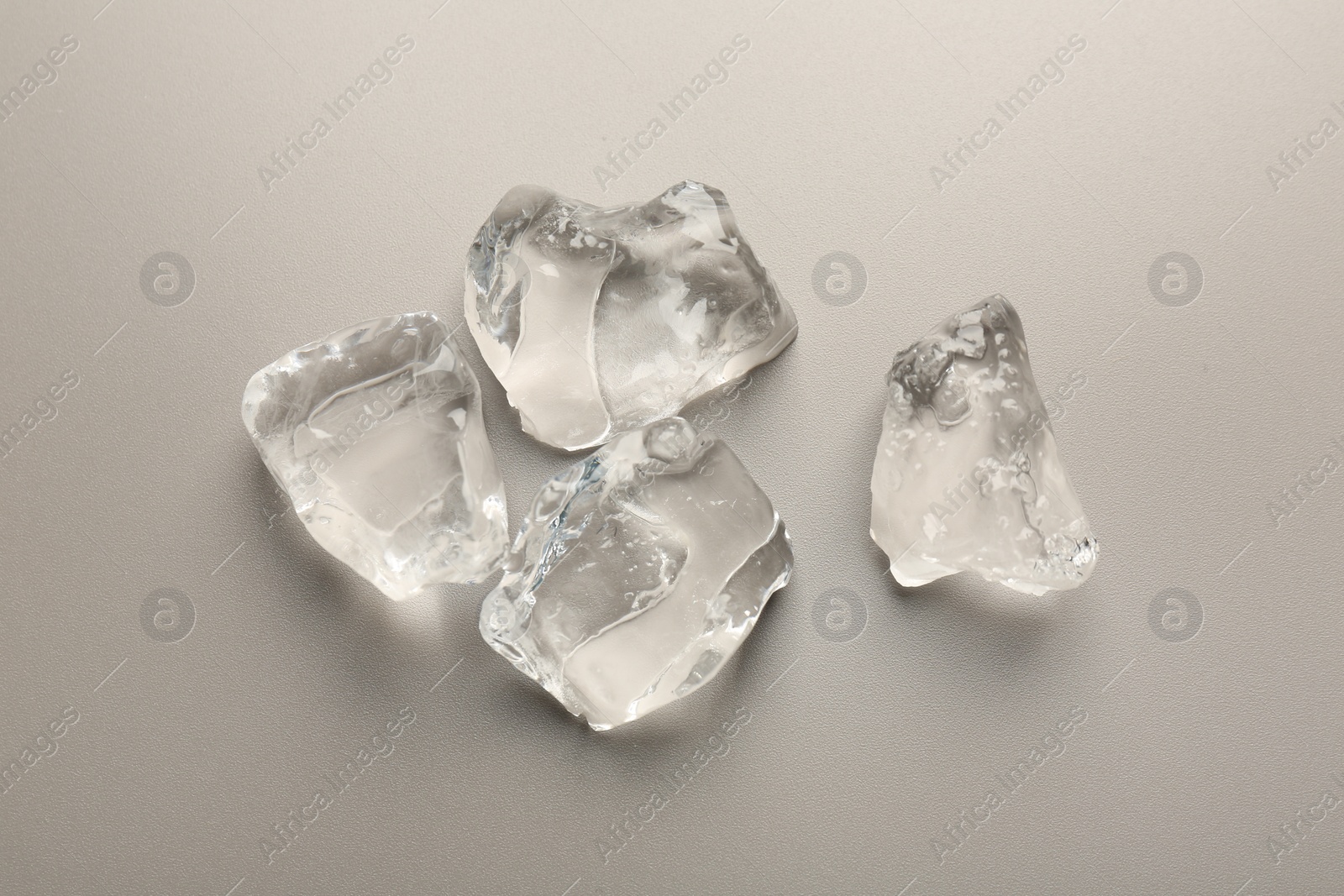 Photo of Pieces of crushed ice on grey background, top view