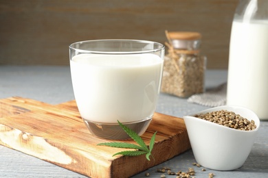 Composition with glass of hemp milk on grey wooden table, closeup