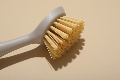 Photo of Cleaning brush on beige background, closeup. Space for text