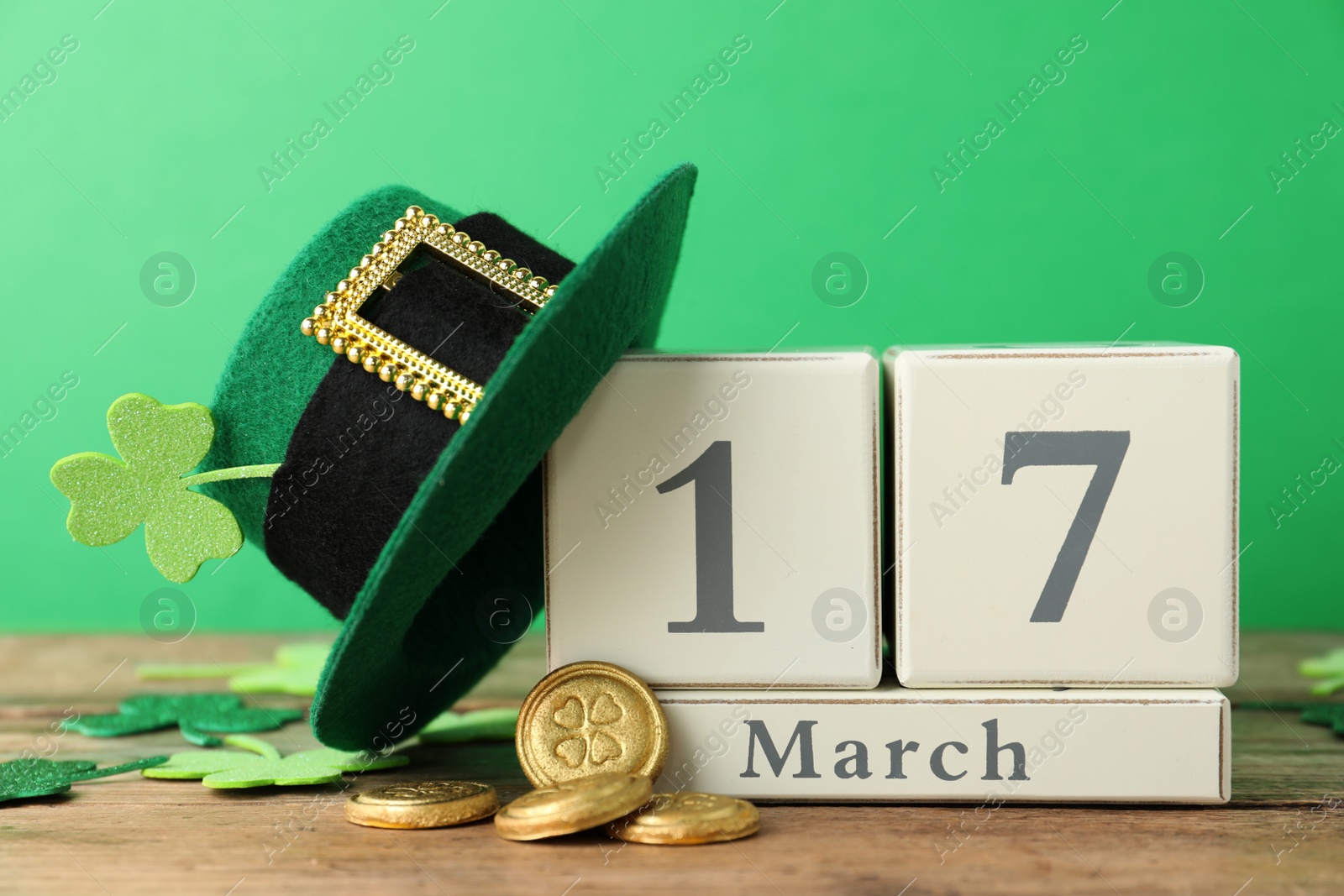 Photo of Composition with block calendar on wooden table. St. Patrick's Day celebration