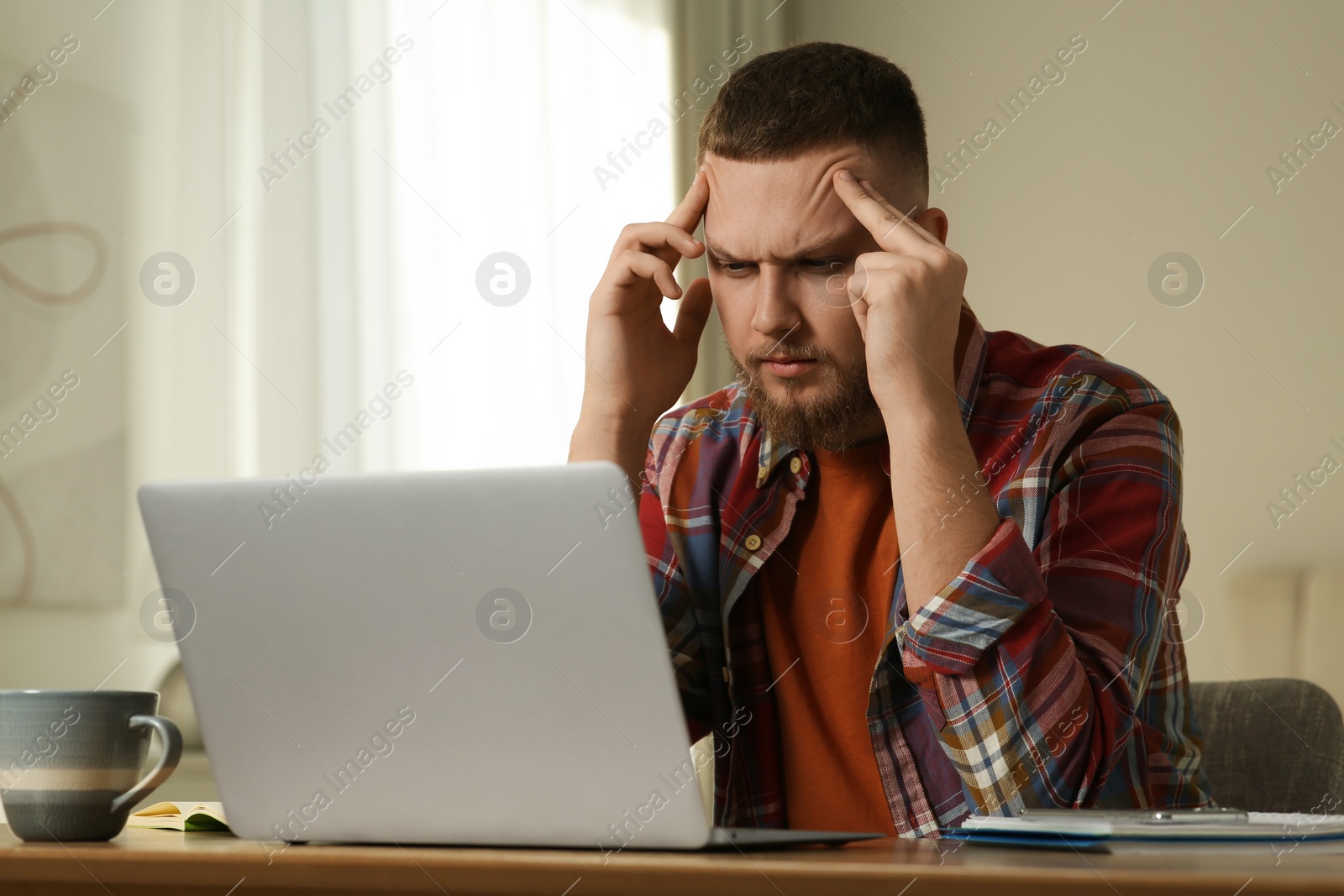 Photo of Online test. Man studying with laptop at home