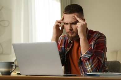 Photo of Online test. Man studying with laptop at home