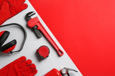 Photo of Flat lay composition with tools, safety equipment and space for text on color background