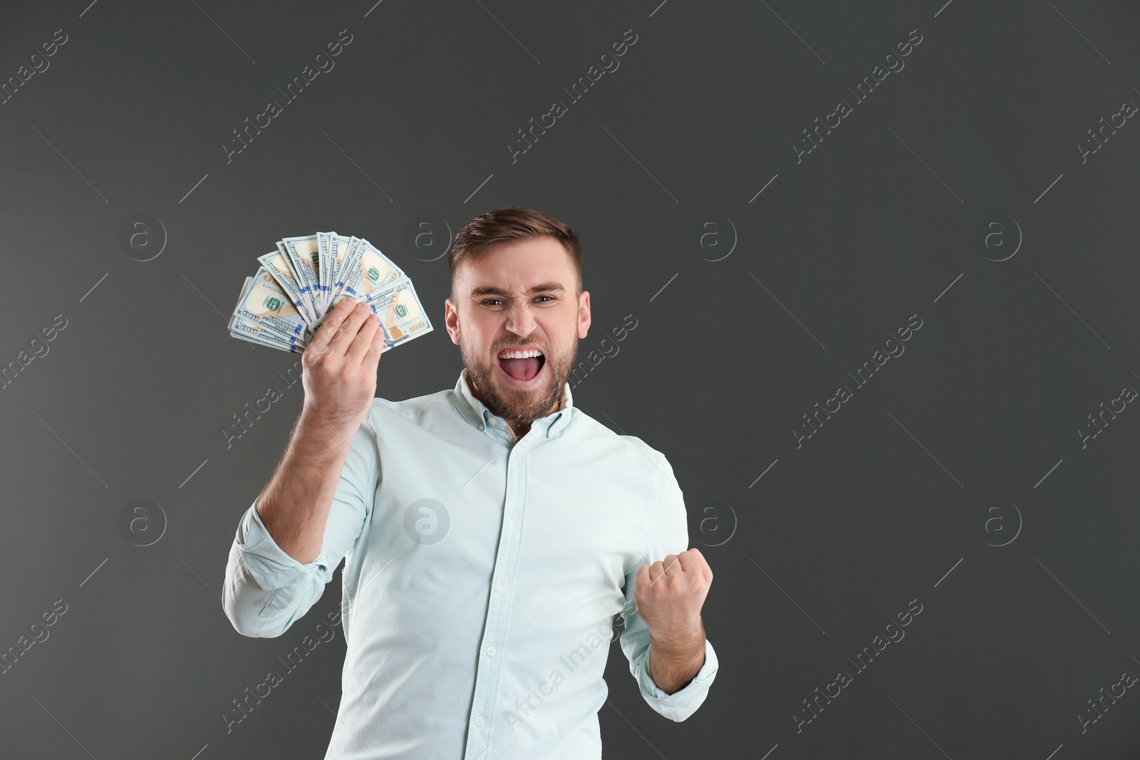 Photo of Portrait of emotional young man with money on grey background. Space for text