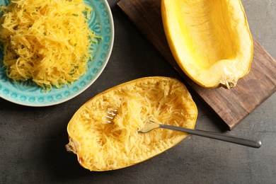 Flat lay composition with cooked spaghetti squash and fork on gray background