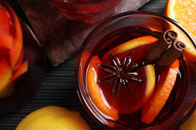Aromatic punch drink and ingredients on black table, flat lay