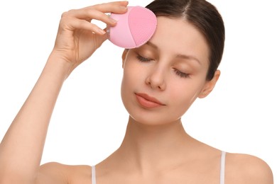 Washing face. Young woman with cleansing brush on white background