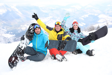 Friends with snowboards at mountain resort. Winter vacation