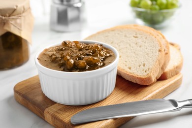 Delicious gooseberry jam and slices of bread on white table