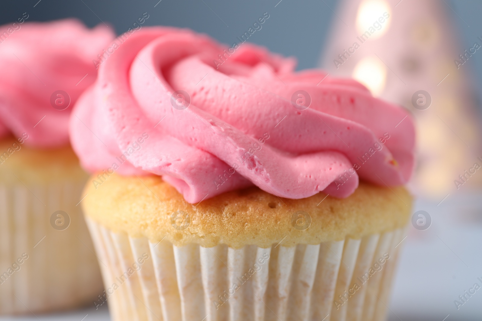 Photo of Delicious cupcake with bright cream on light background, closeup